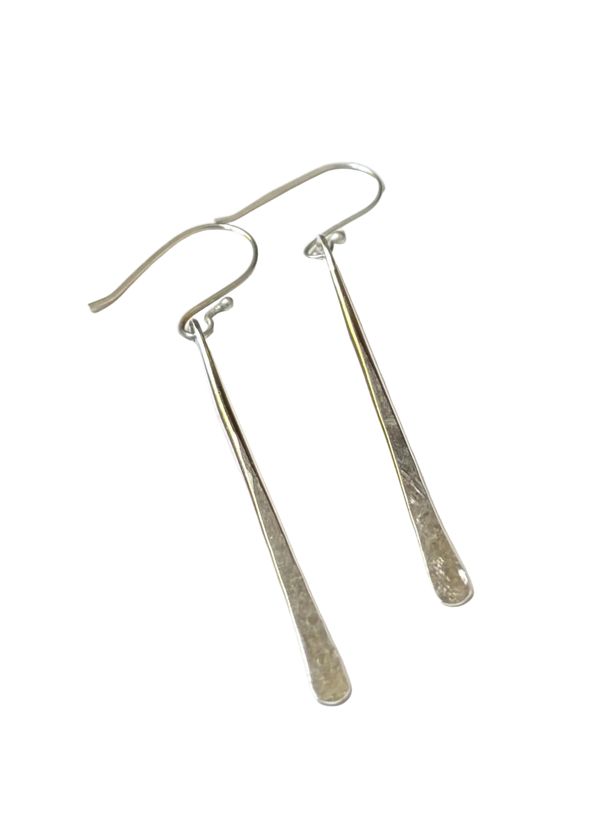 A pair of silver drop earrings with long, textured bar-shaped dangles and fishhook wires, displayed on a clean white background.